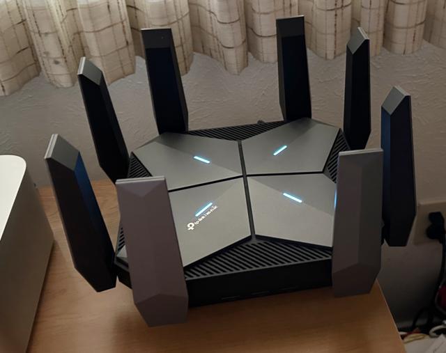 A TP-Link Archer AXE300 router sitting on a desktop